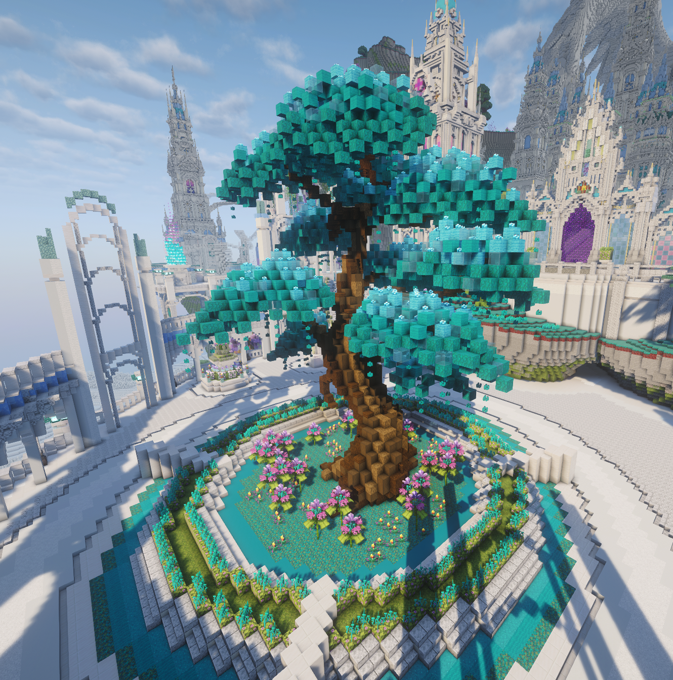Árbol enorme de hojas turquesas sobre un estanque circular con flores, rodeado por la arquitectura blanca y gris del spawn.